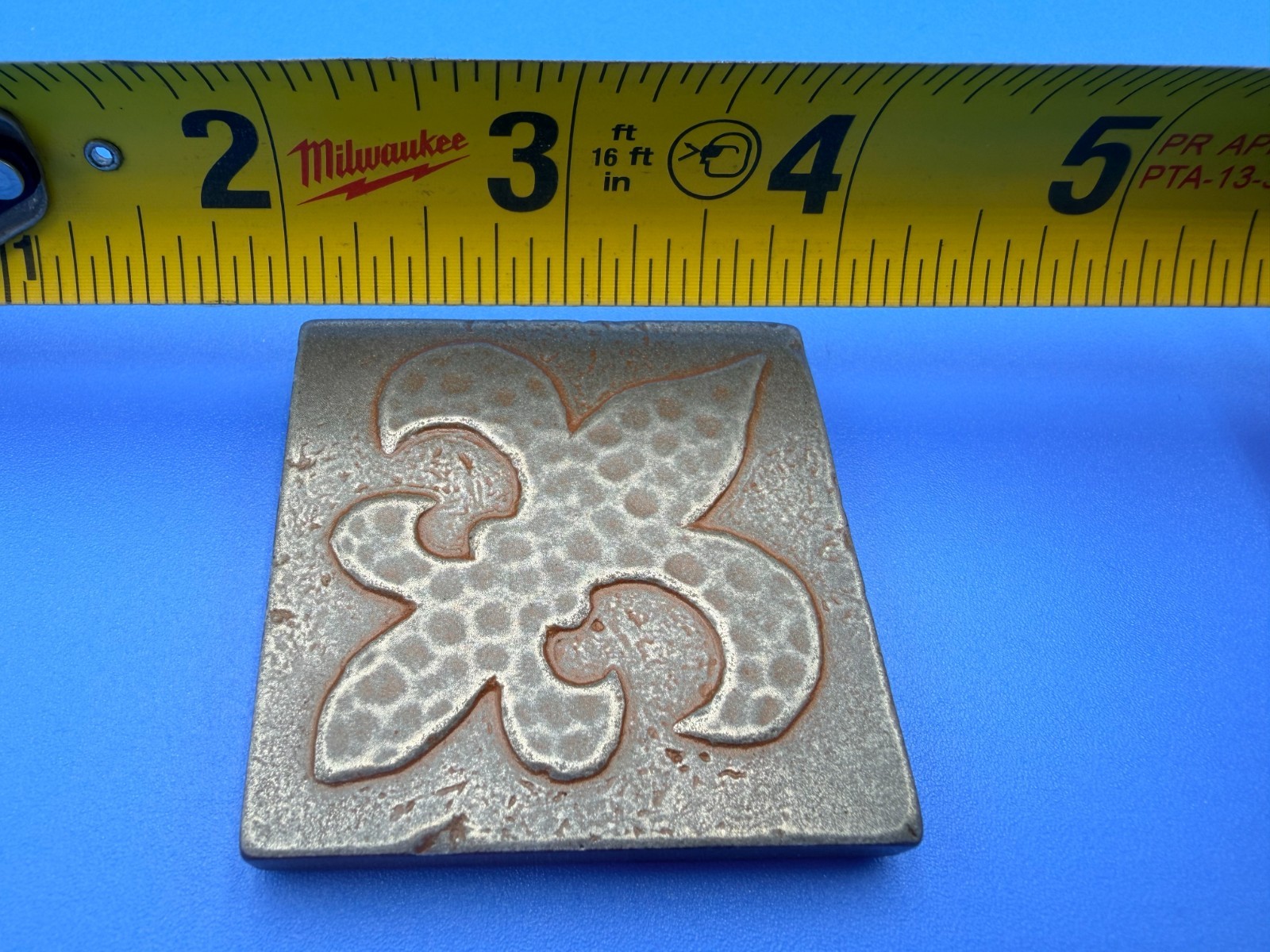 New Questech 2×2 Fleur-de-lis Insert Accent Composite Tile w/ Aged Iron Finish